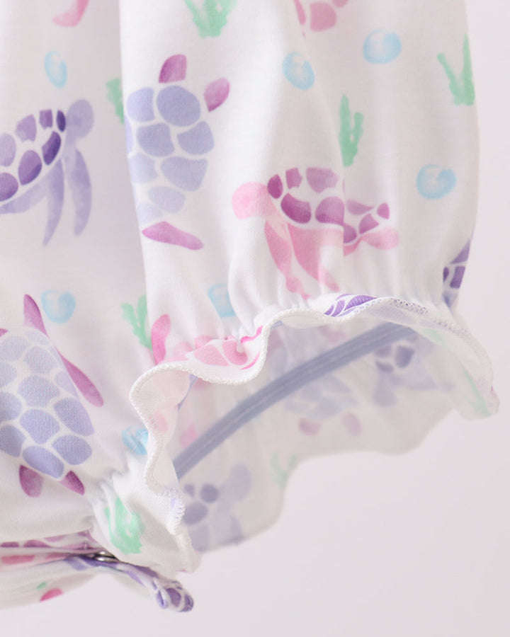 Baby romper with colorful turtle design on a white background