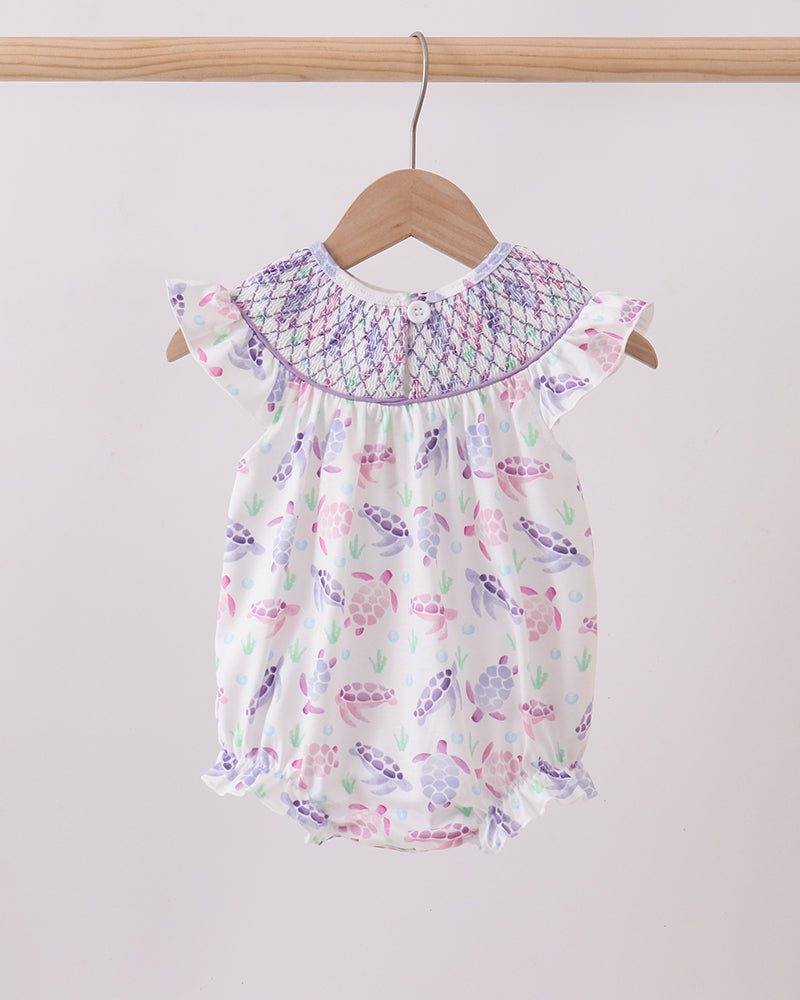 Baby romper with butterfly pattern on a hanger against a plain background
