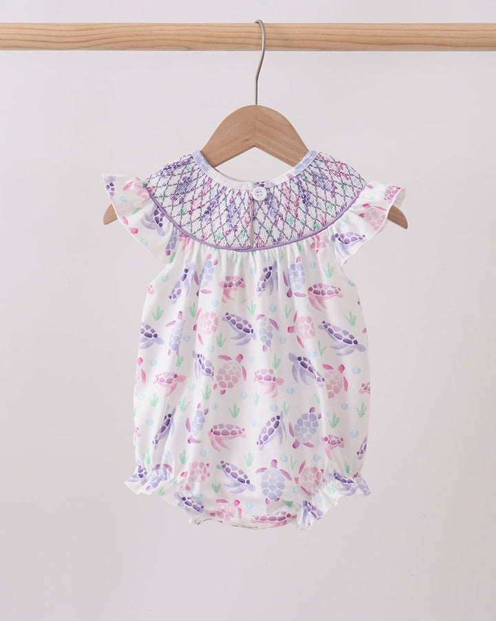 Baby romper with butterfly pattern on a hanger against a plain background