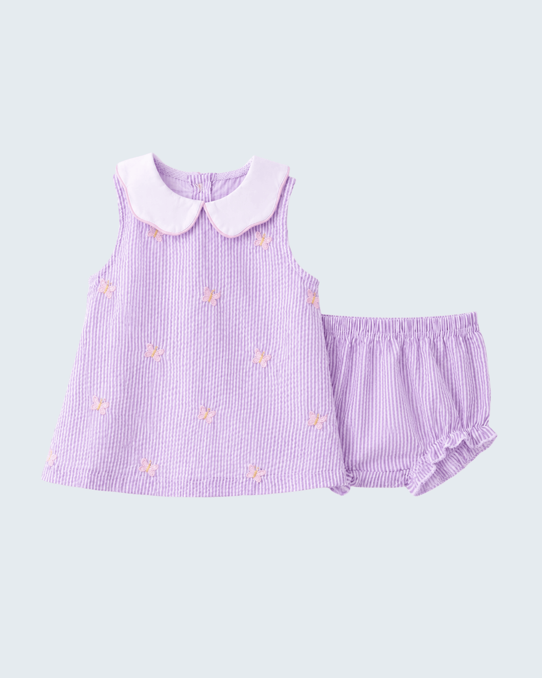 Purple dress with pink collar and matching shorts on a light gray background