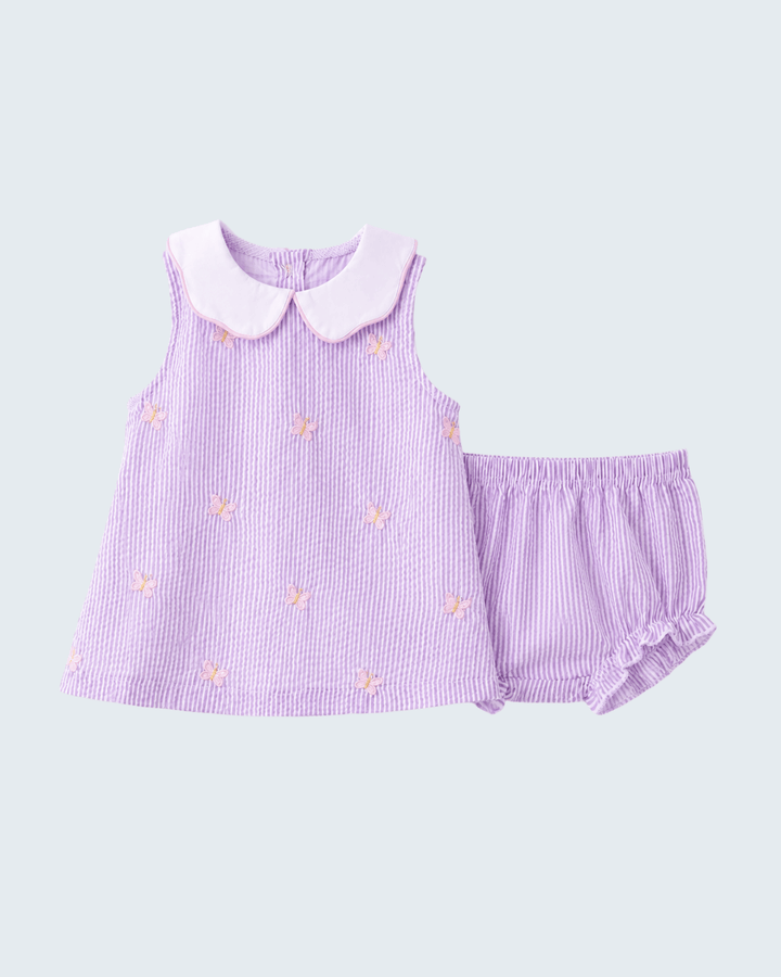 Purple dress with pink collar and matching shorts on a light gray background