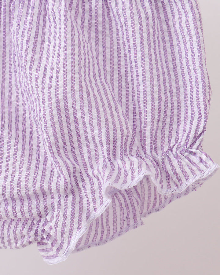 Purple and white striped fabric with ruffled edge on a light gray background