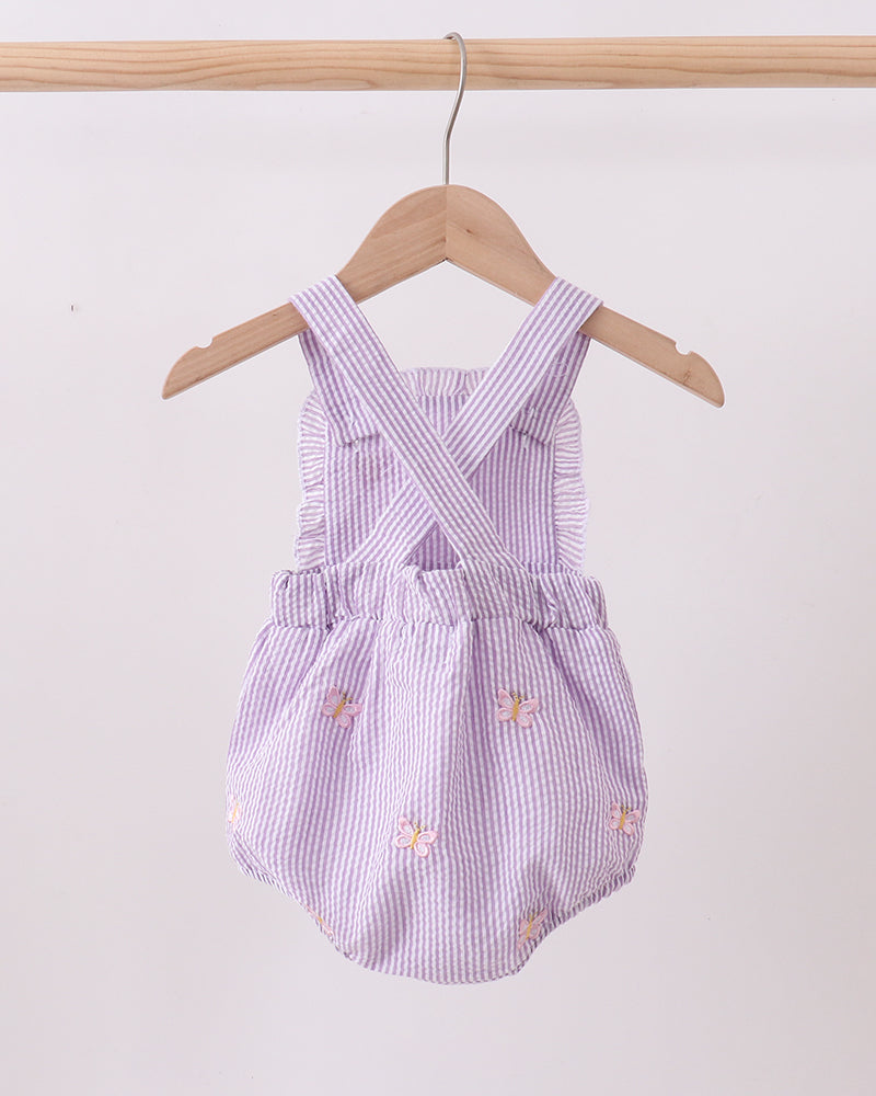 Purple checkered baby romper with floral embroidery on a wooden hanger against a white background