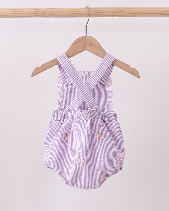 Purple checkered baby romper with floral embroidery on a wooden hanger against a white background