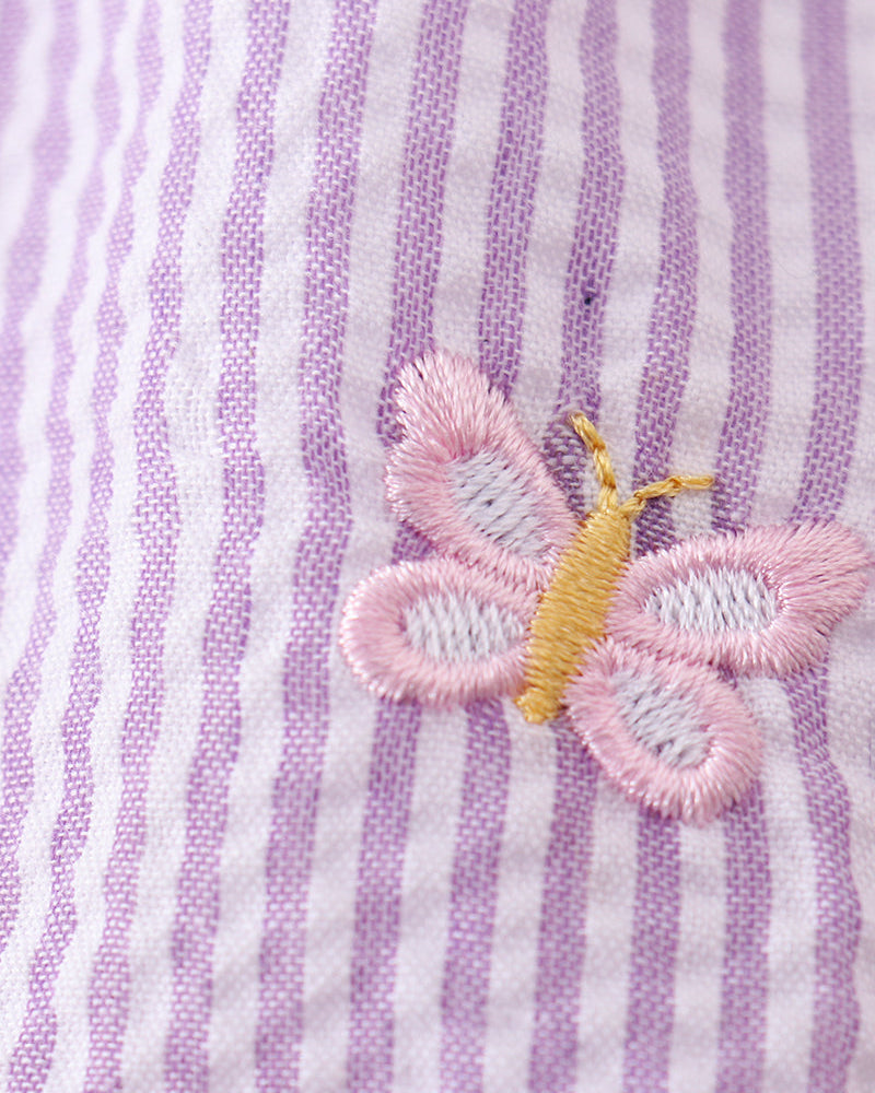 Butterfly embroidered on a purple and white striped fabric