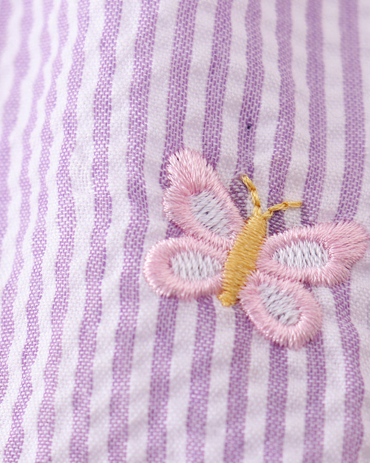 Butterfly embroidered on a purple and white striped fabric