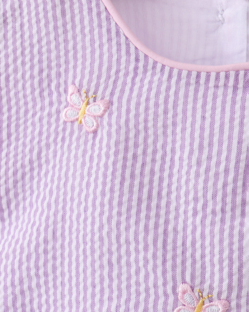 Close-up of a purple and white striped fabric with embroidered butterflies.