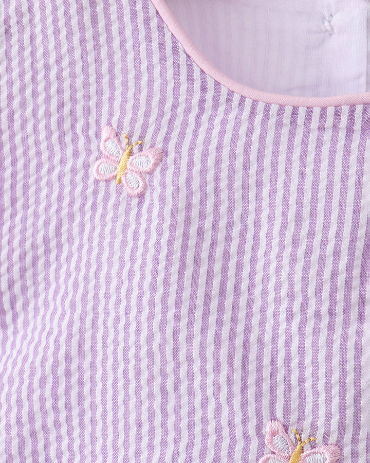 Close-up of a purple and white striped fabric with embroidered butterflies.