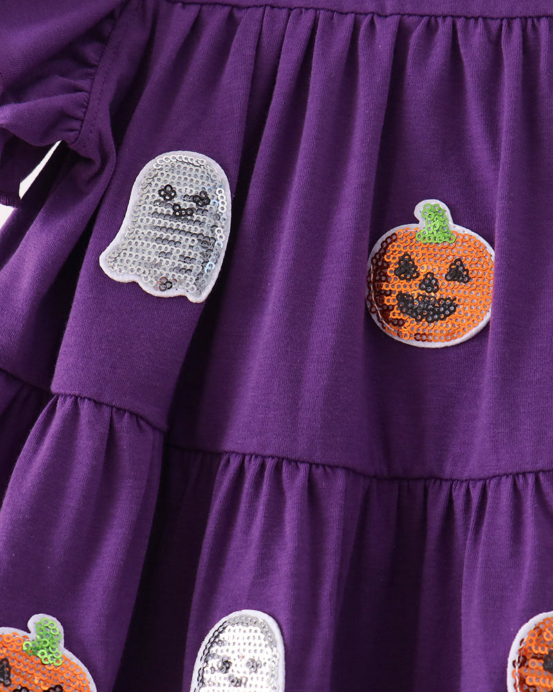 Close-up of a purple tiered dress with sequined ghost and pumpkin patches on the front.