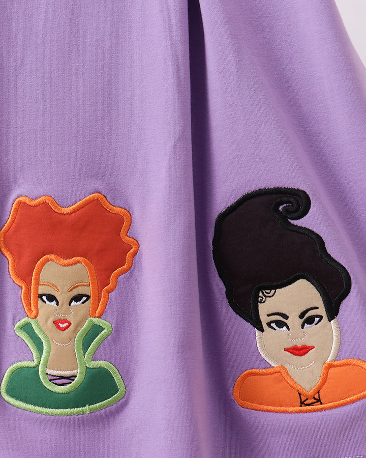 Purple dress with two witch face appliqués on the front