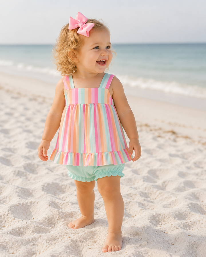 Toddler girl standing on a sandy beach