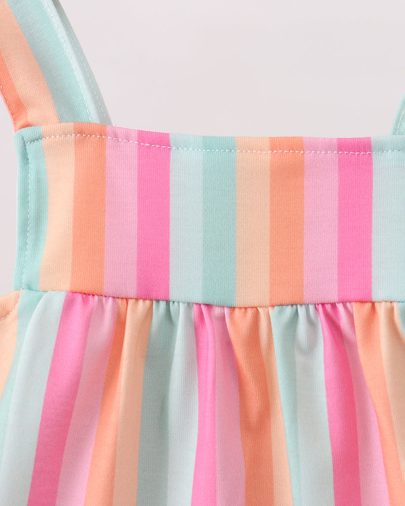 Close-up of a colorful striped dress with pink, orange, and blue pattern.