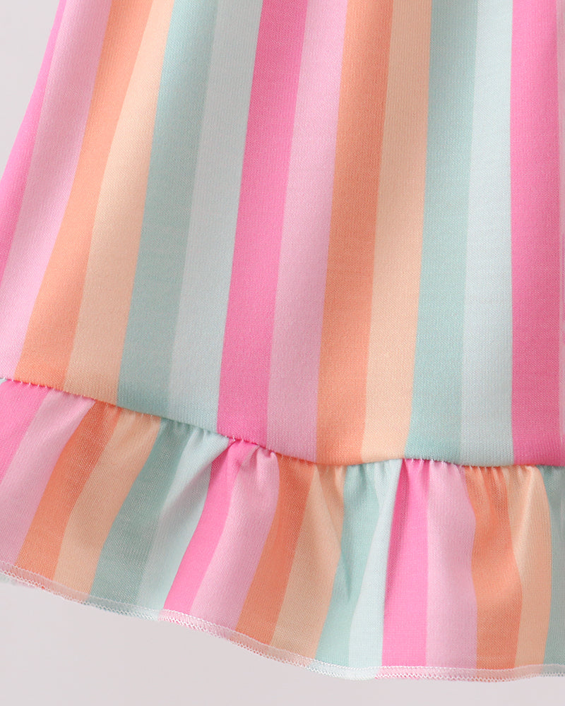 Close-up of a colorful striped dress with pink, orange, and blue horizontal stripes on a light background.