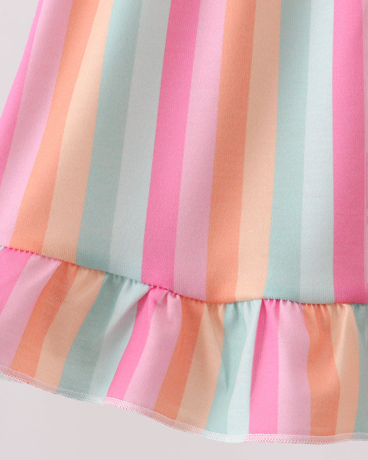 Close-up of a colorful striped dress with pink, orange, and blue horizontal stripes on a light background.