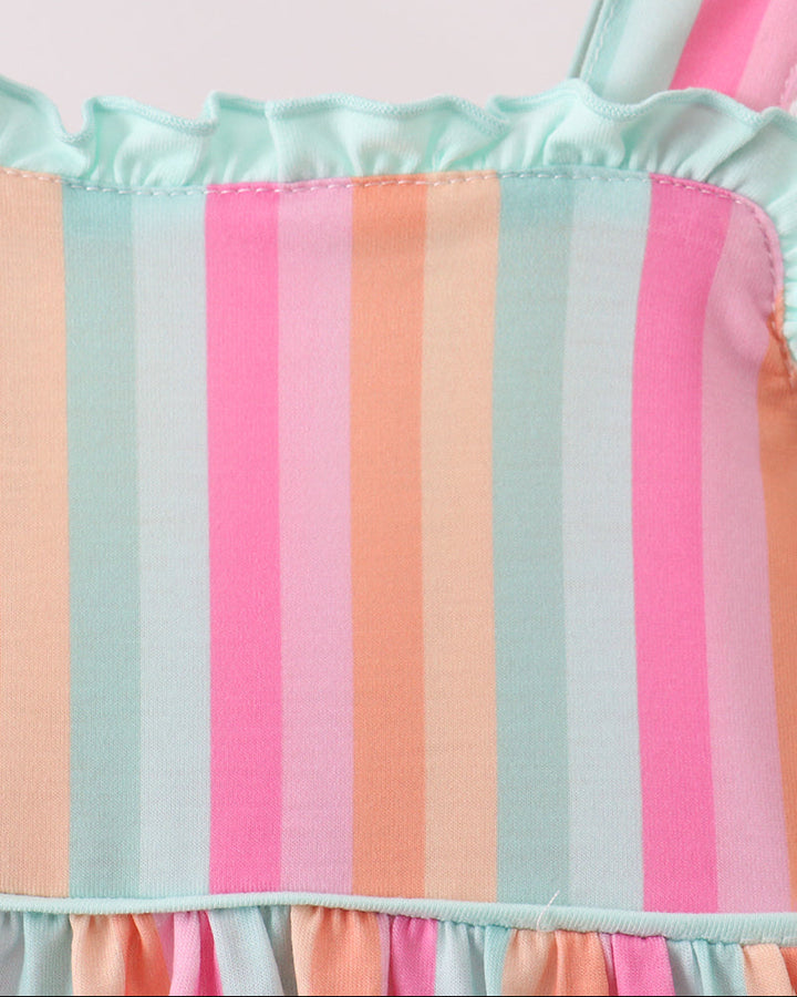 Pastel striped fabric with ruffled edges on a light pink background