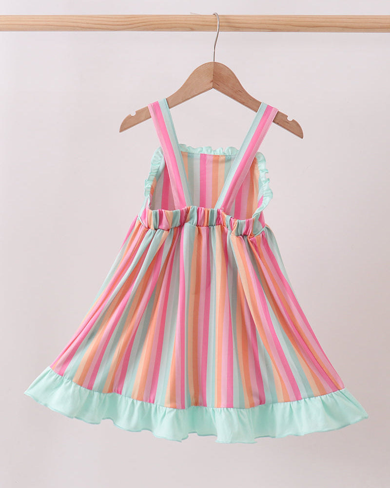 Colorful striped dress on a hanger against a light pink background
