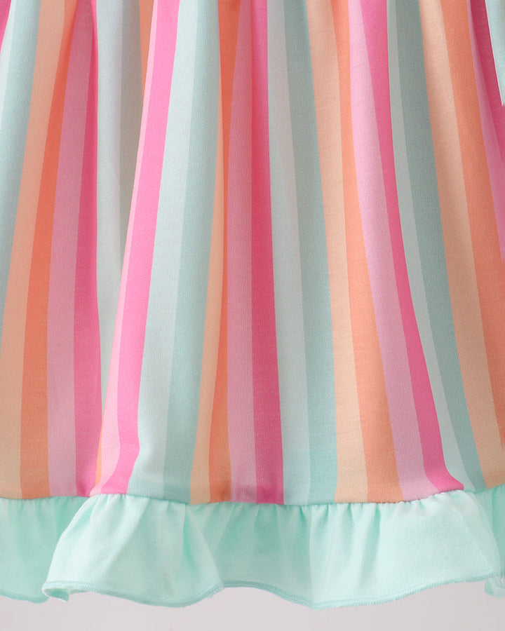 Close-up of a colorful striped fabric with a ruffled edge on a light background