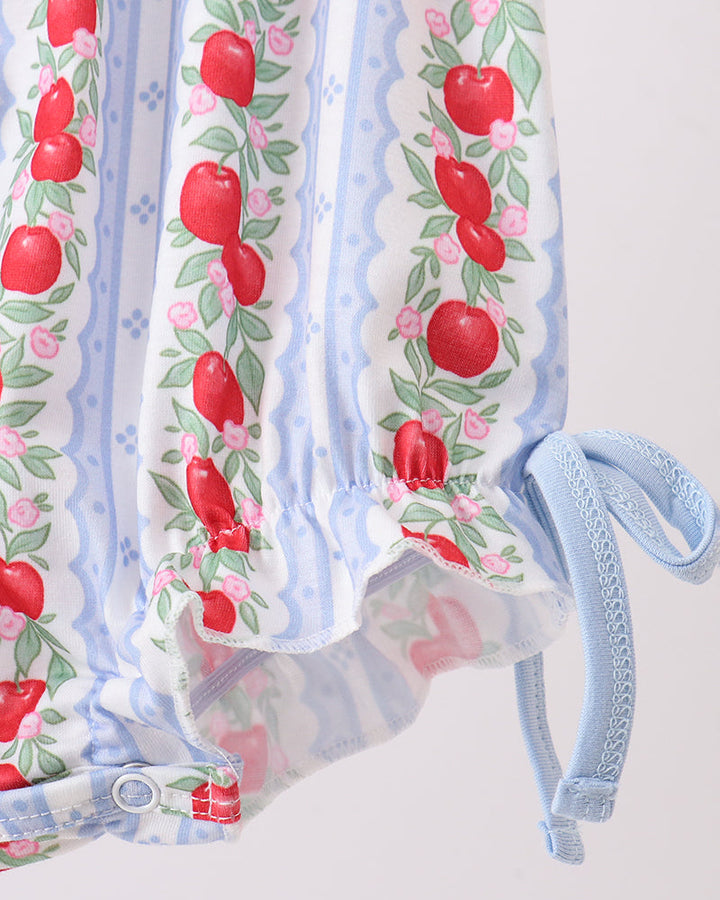 Baby outfit with red apple pattern on a white background