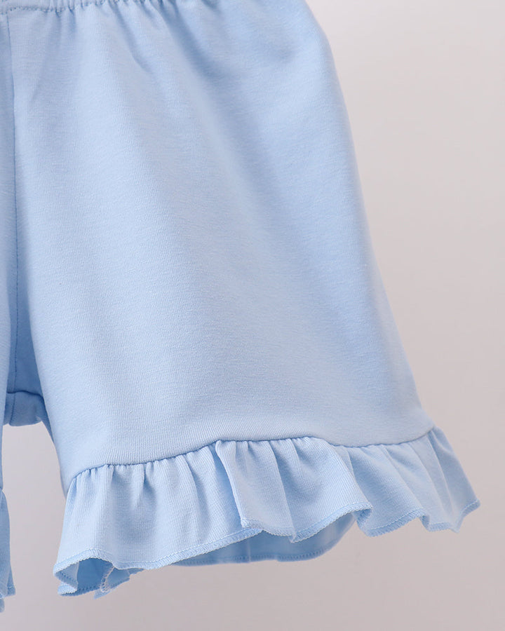 Light blue shorts with ruffled hem on a neutral background