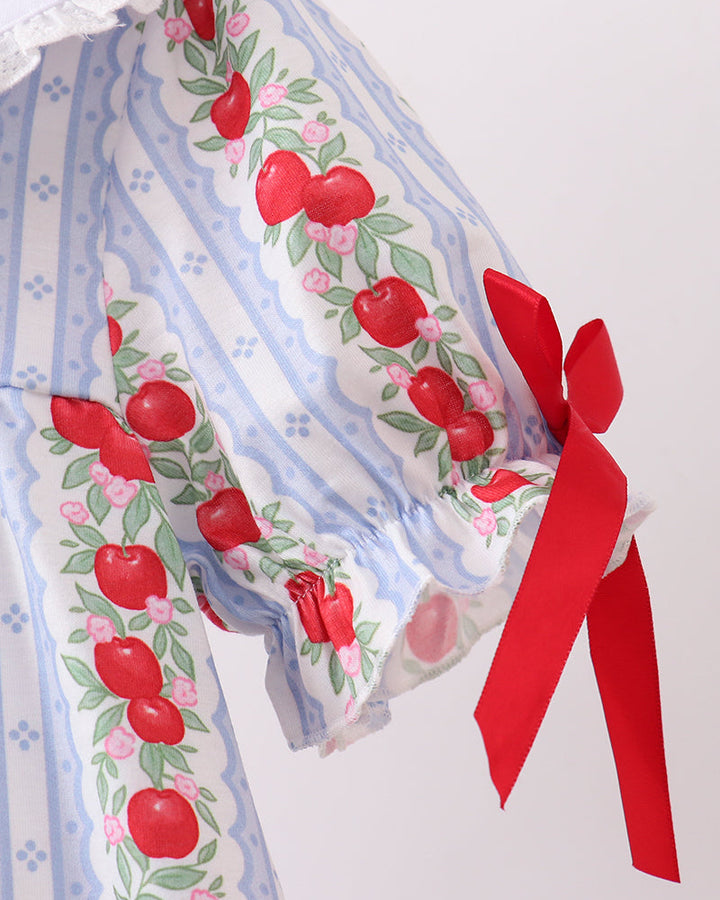 Fabric with red apple pattern and a red ribbon on a white background