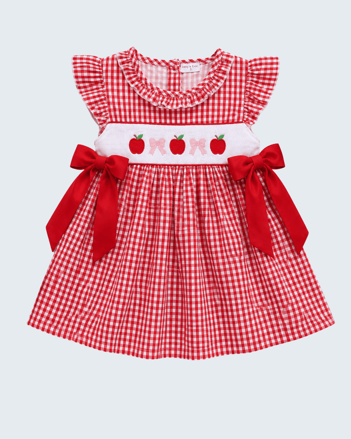 Red and white checkered dress with ruffled collar and red bows on a light gray background