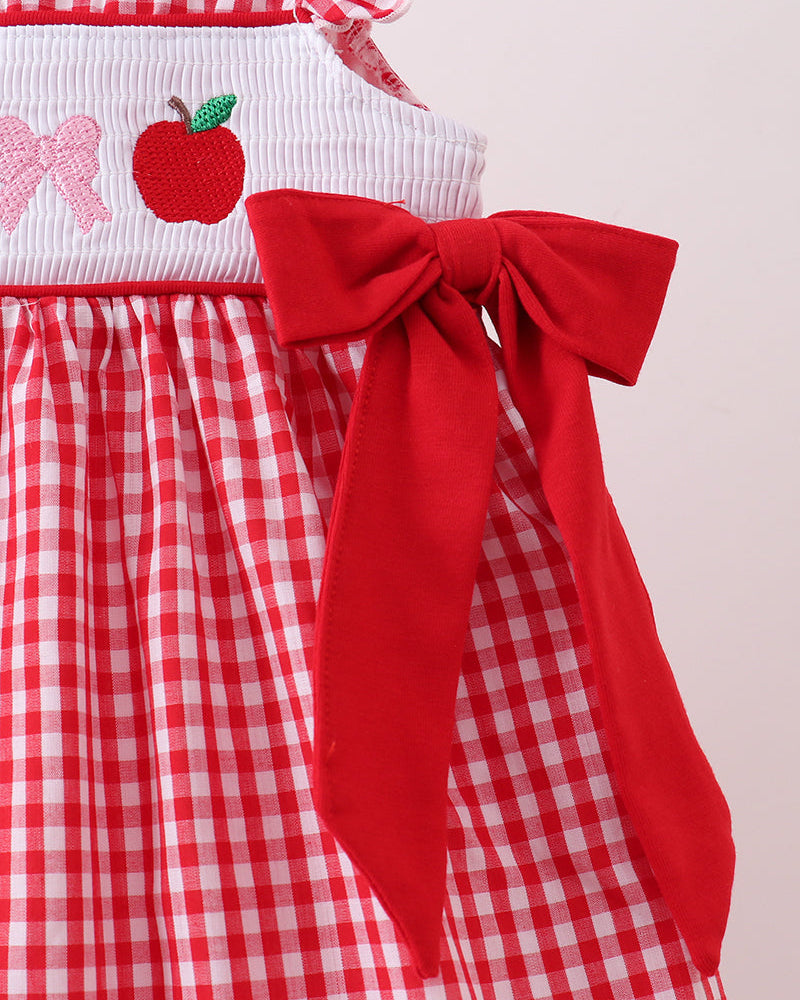 Red checkered dress with a large bow on a plain background