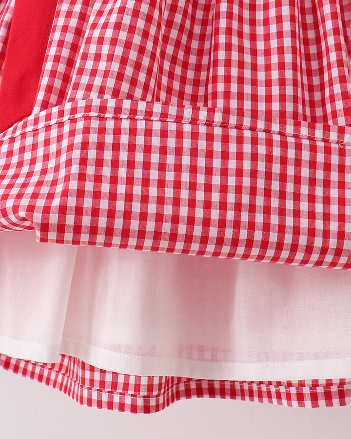 Red and white checkered fabric with a light pink overlay on a plain background