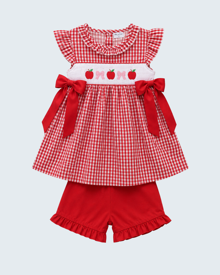 Red checkered dress with ruffles and apple design on a white background
