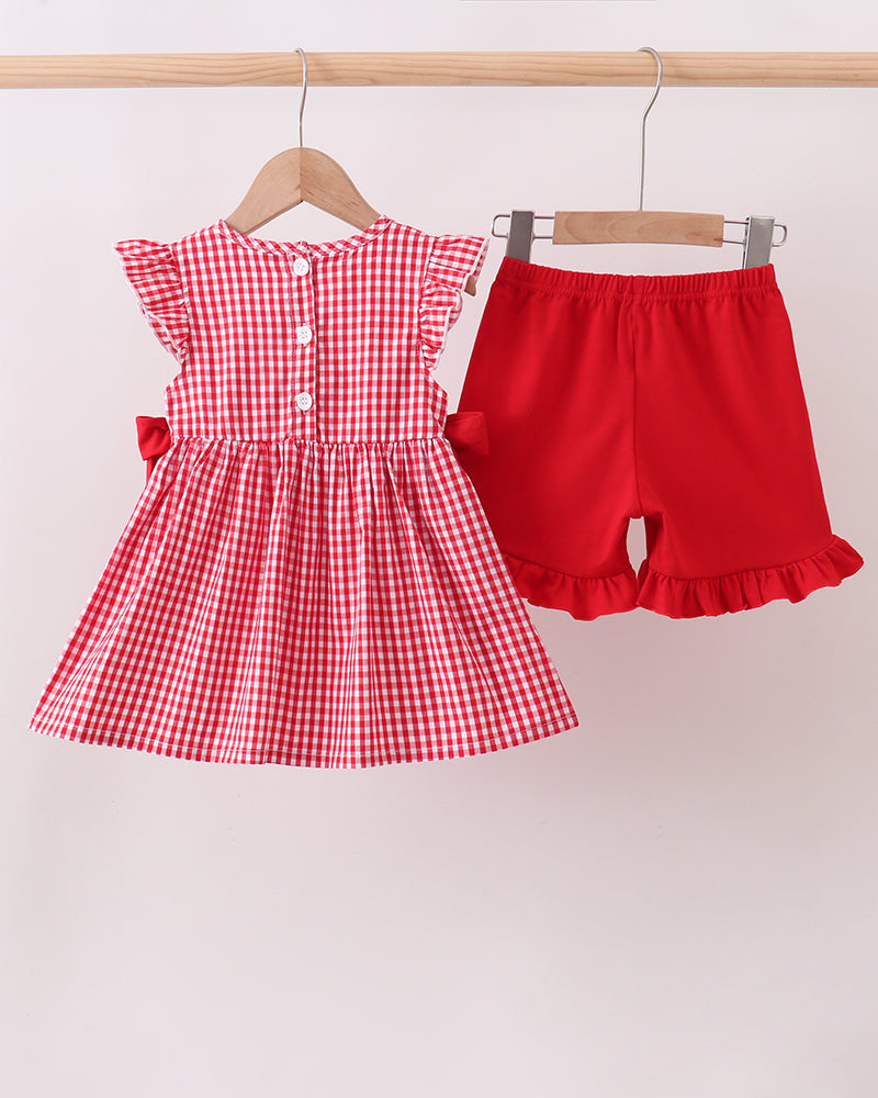 Red checkered dress and shorts on hangers against a white background