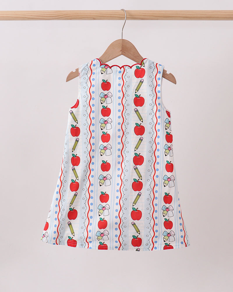 White sleeveless kids dress with vertical apple and pencil pattern and red scalloped hem