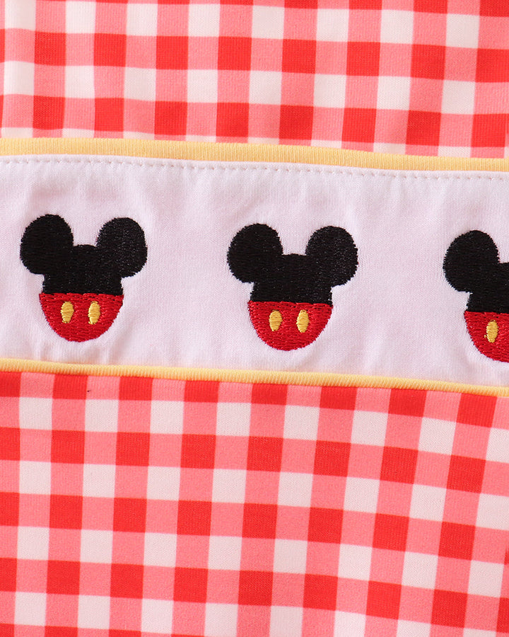 Embroidered character on red plan fabric