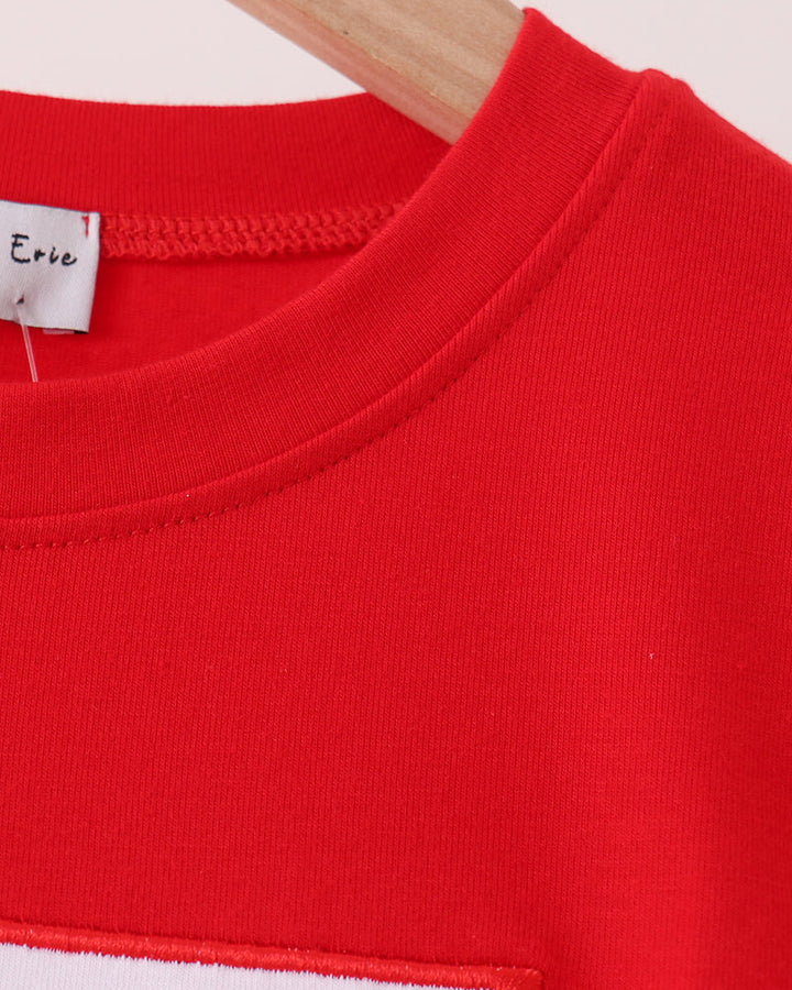 Red long-sleeve crew-neck top with embroidered trim panel