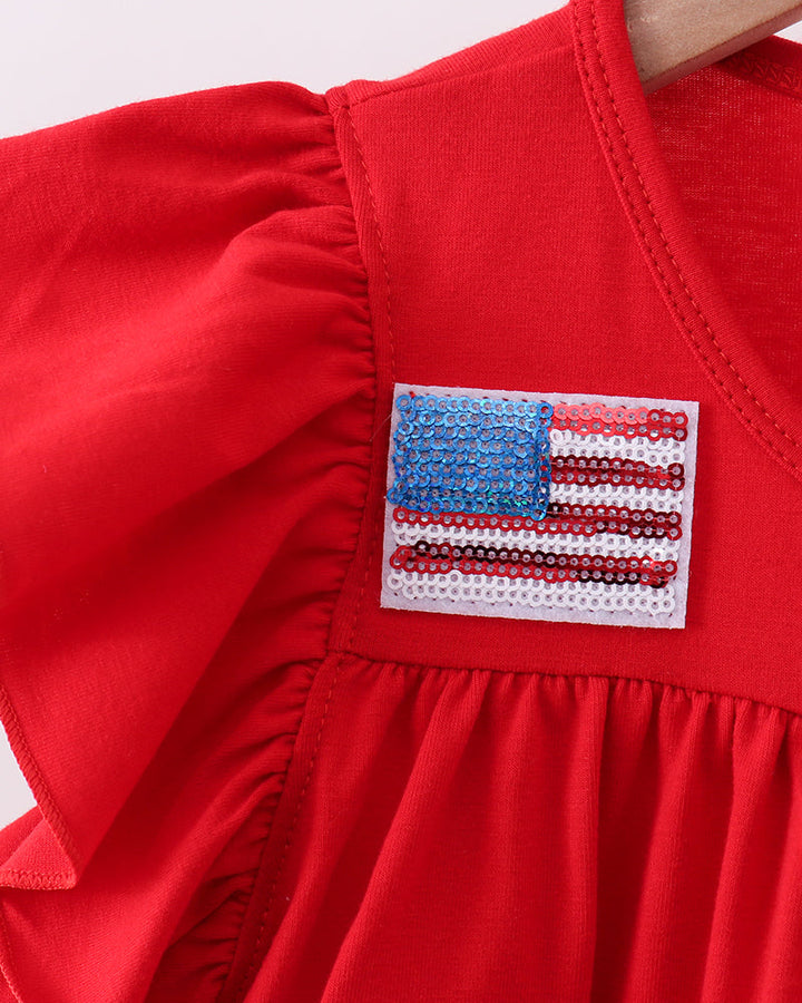 Red dress with American flag patches on a white background