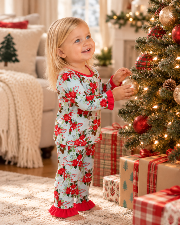 Kids pajama set worn by child: floral bamboo top and pants with red ruffle cuffs