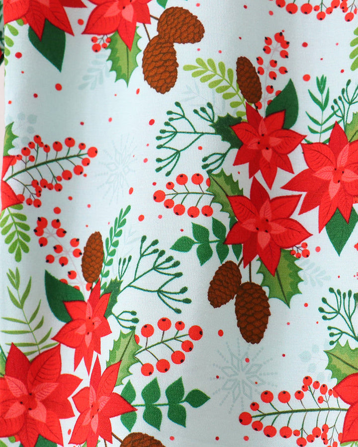 Close-up of light blue bamboo pajama fabric with red poinsettias, berries, and leaves