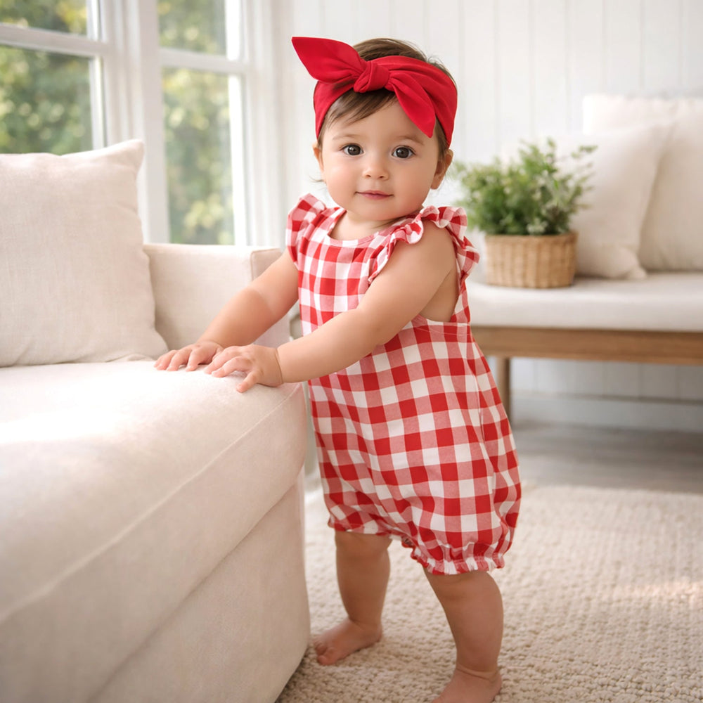 Baby girl in red outfit in livingroom