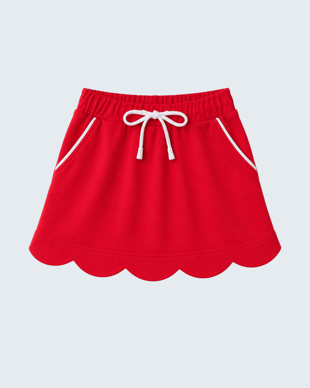 A bright red skort with a scalloped hem, white drawstring, and white piping details, shown against a light gray background.