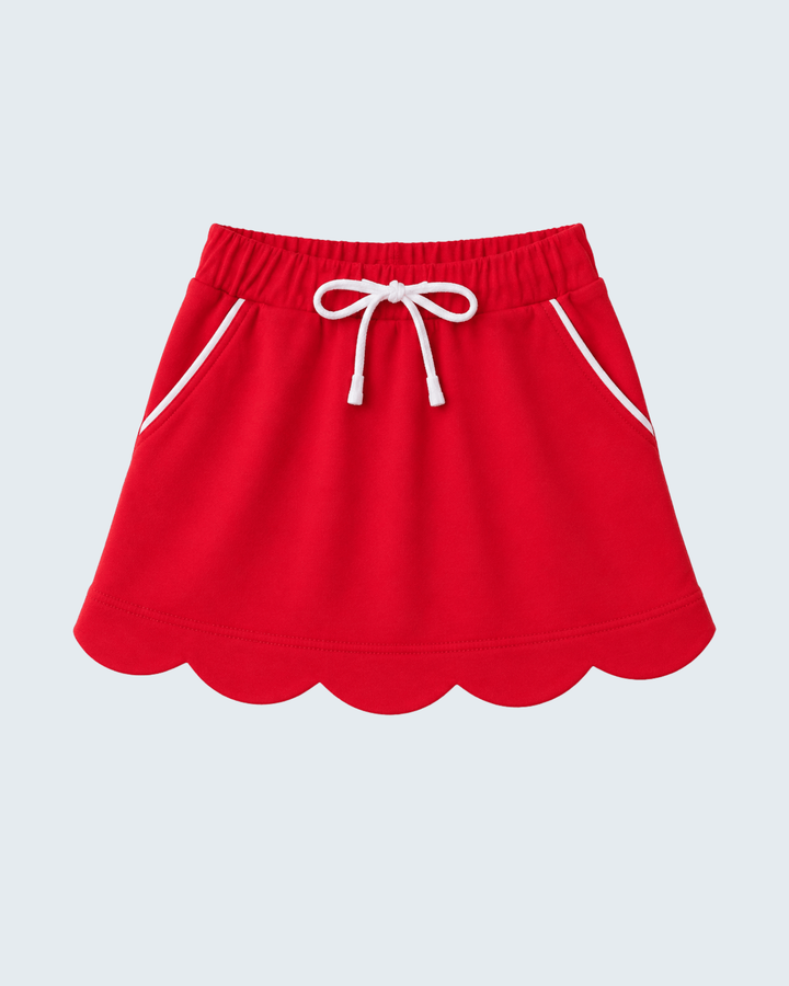A bright red skort with a scalloped hem, white drawstring, and white piping details, shown against a light gray background.