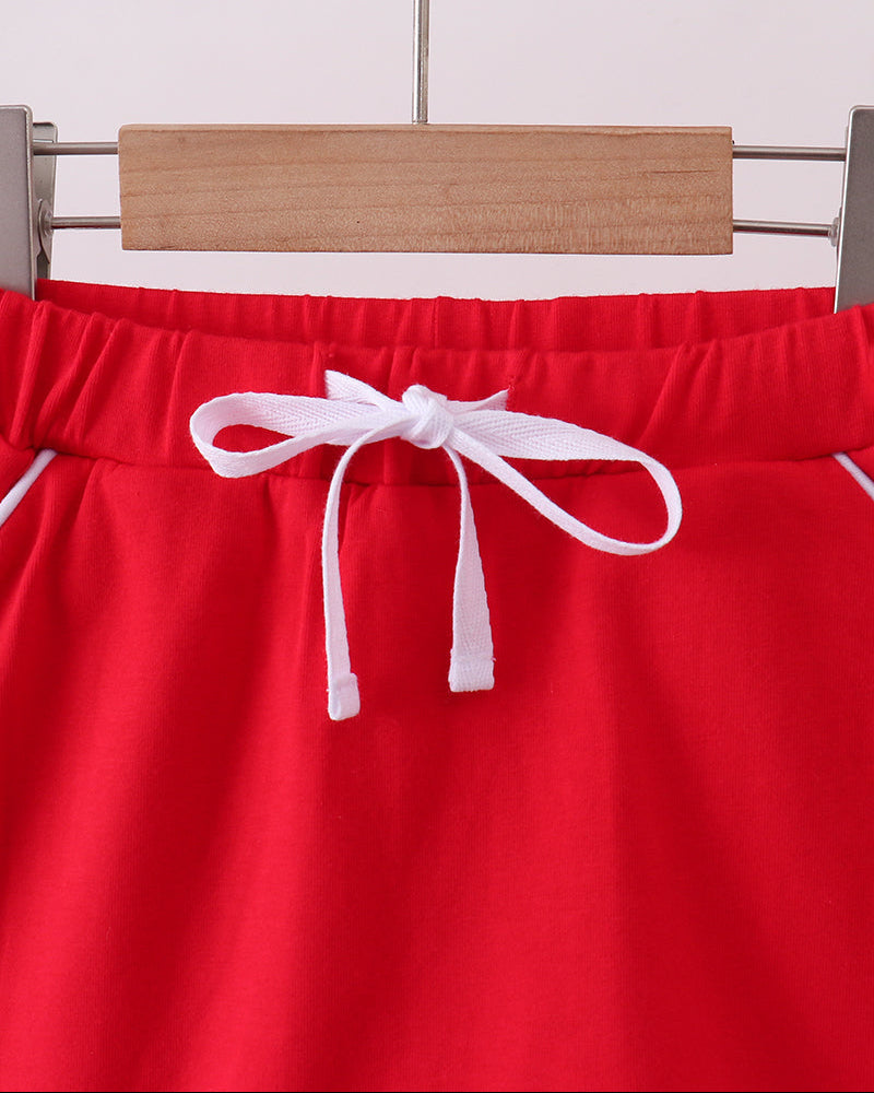 Red bow skort with scalloped hem, elastic waistband and white ribbon tie at front