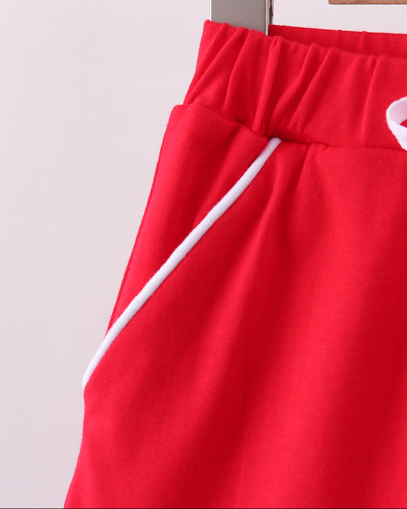Red skort with elastic waist and white tie strings, angled side view