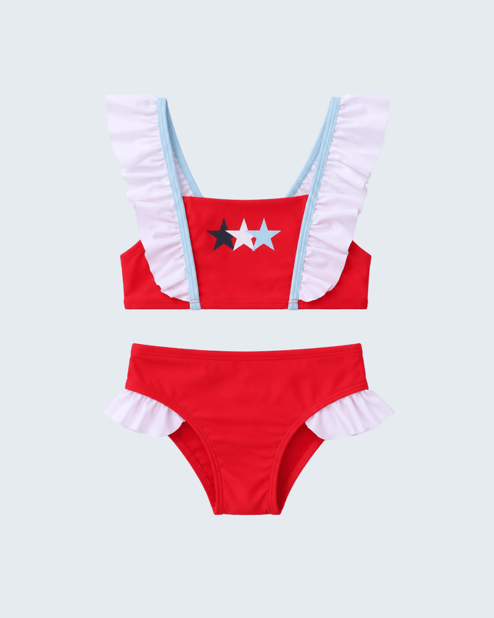 Red bikini set with white ruffled straps and star design on a light gray background