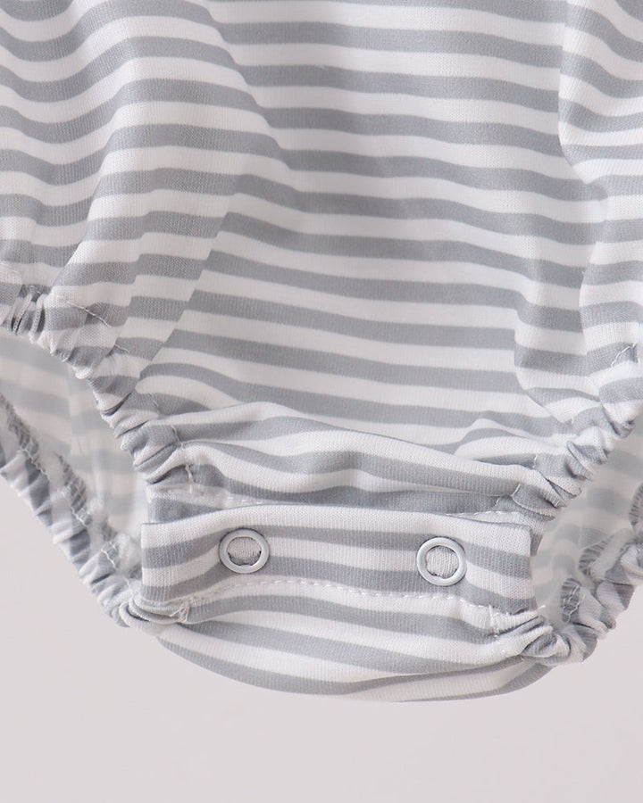 Close-up of a baby romper or bodysuit with a gray and white horizontal stripe pattern and snap closures at the crotch.