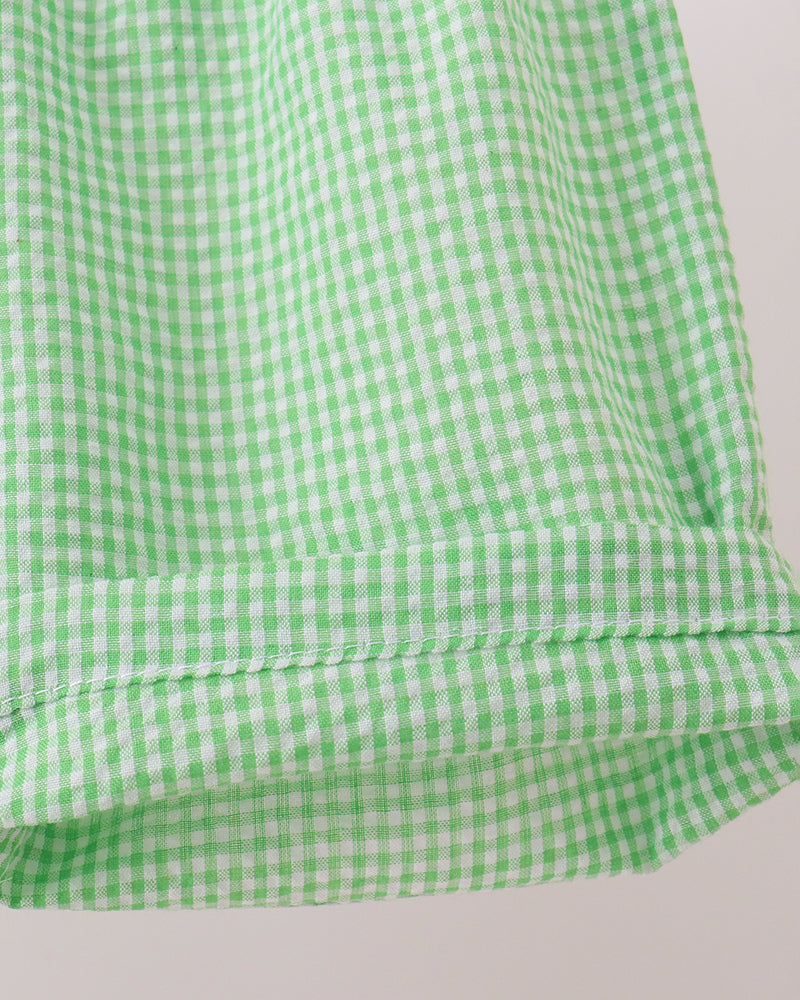Green and white checkered fabric on a light gray background