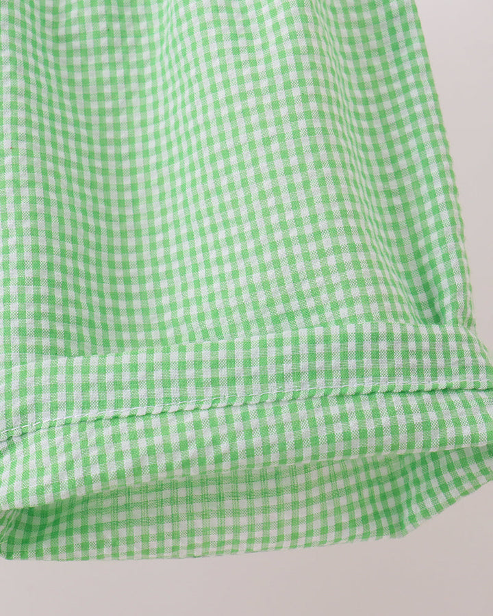 Green and white checkered fabric on a light gray background