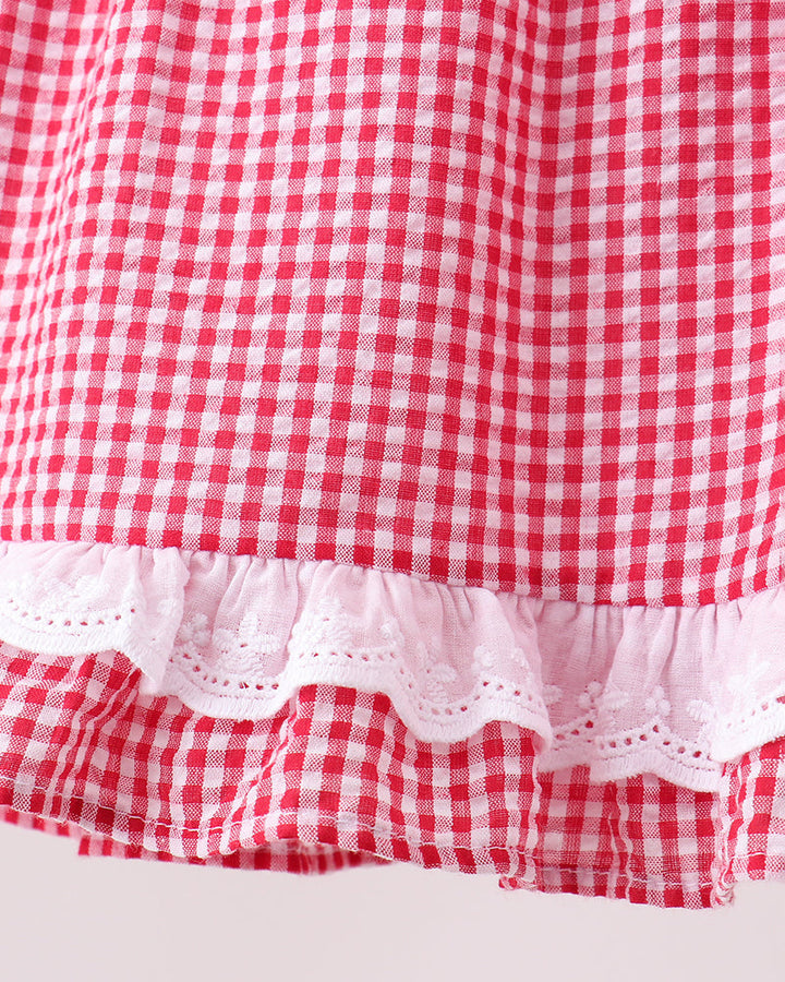 Red and white checkered fabric with a ruffled edge on a light gray background