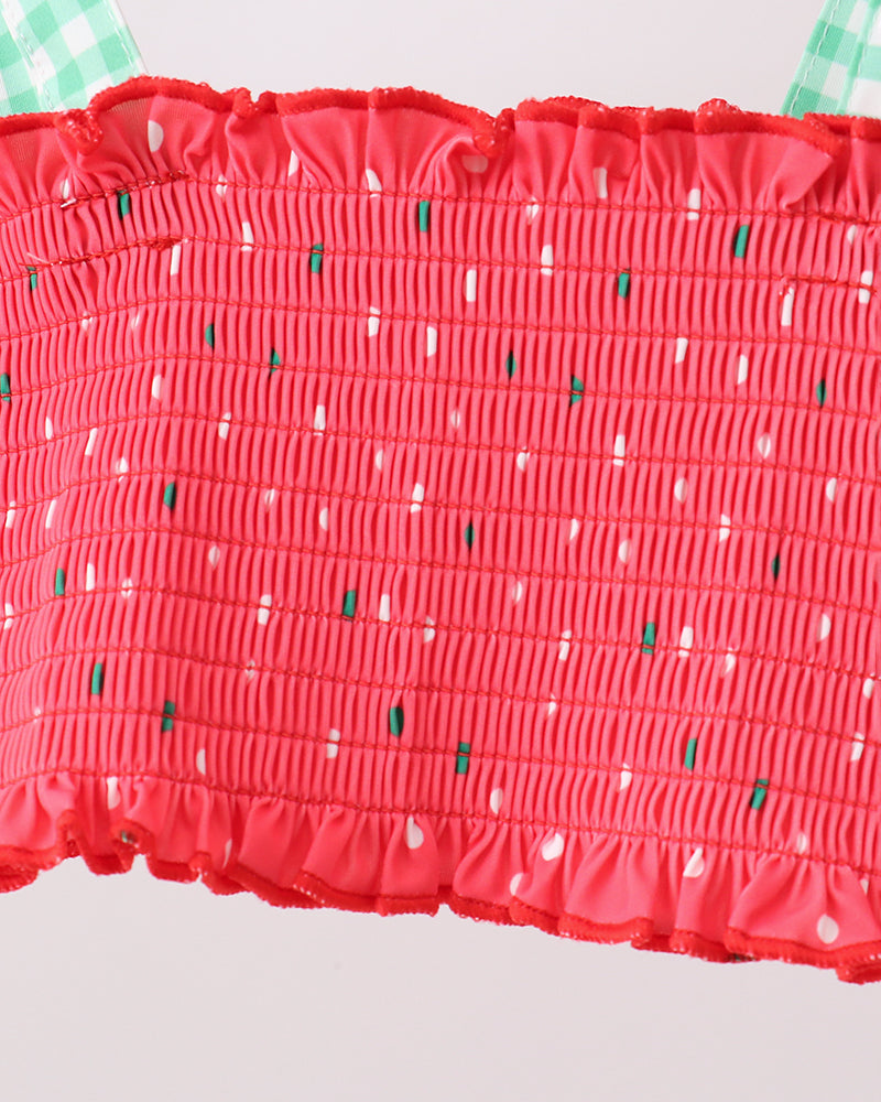 Red smocked top with watermelon pattern on a light gray background