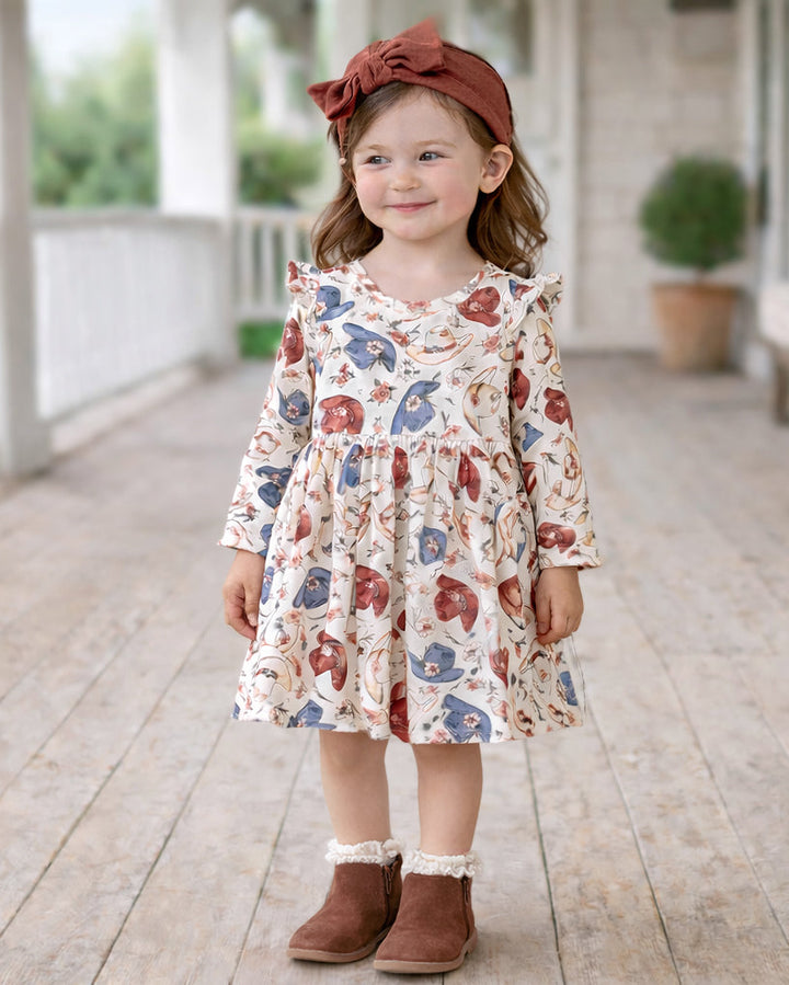 Bamboo cowgirl dress with cream cowboy print, long sleeves and gathered skirt