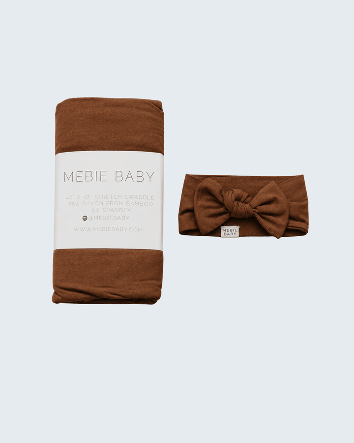 Rust bamboo swaddle and knotted head wrap, folded brown hat and blanket set