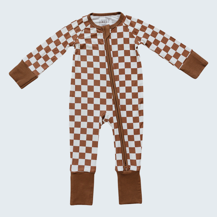 Checkered baby onesie with brown and white pattern on a light gray background