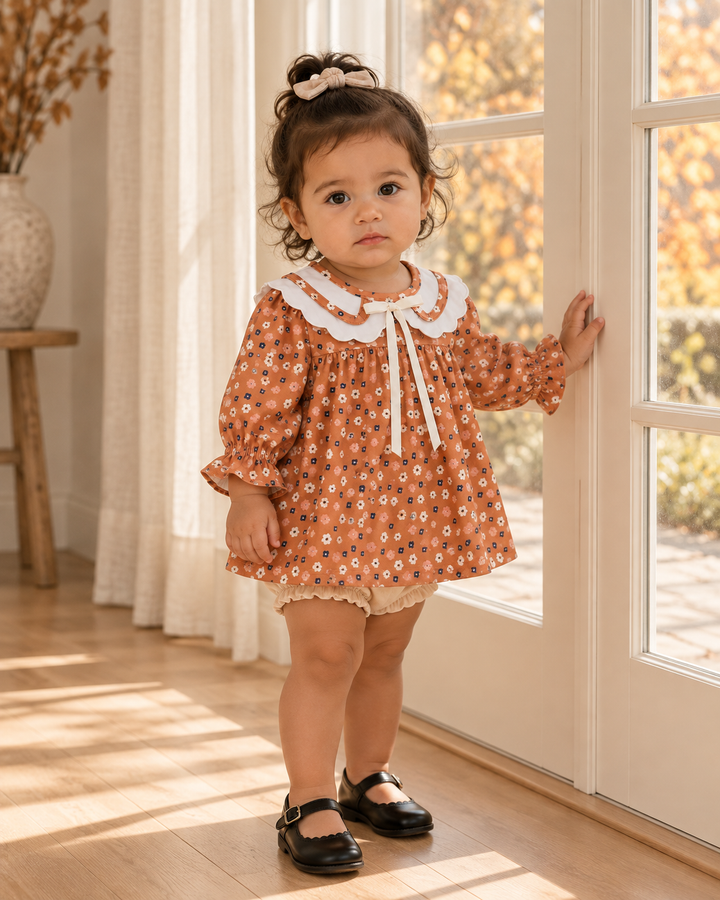 Rust floral dress with white Peter Pan collar and matching cream bloomer shorts on child